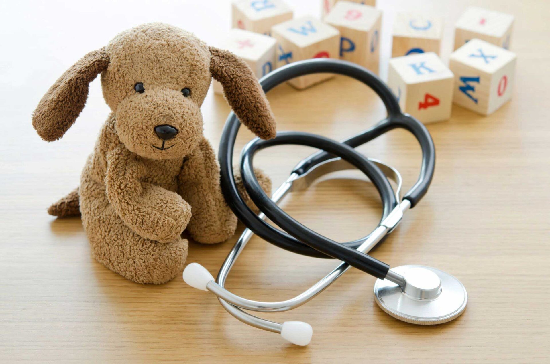 A stethoscope and a teddy bear on top of a table.